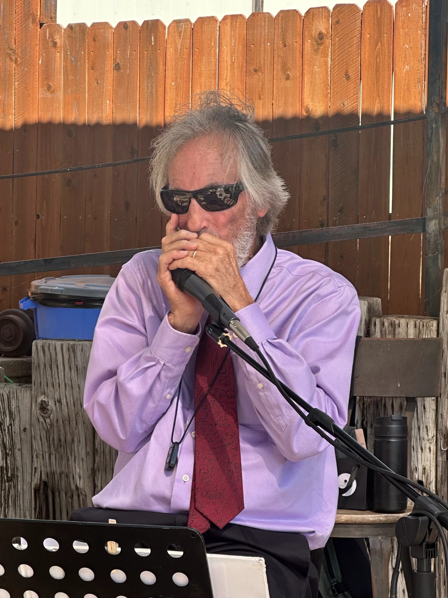 Phil playing harmonica into a microphone